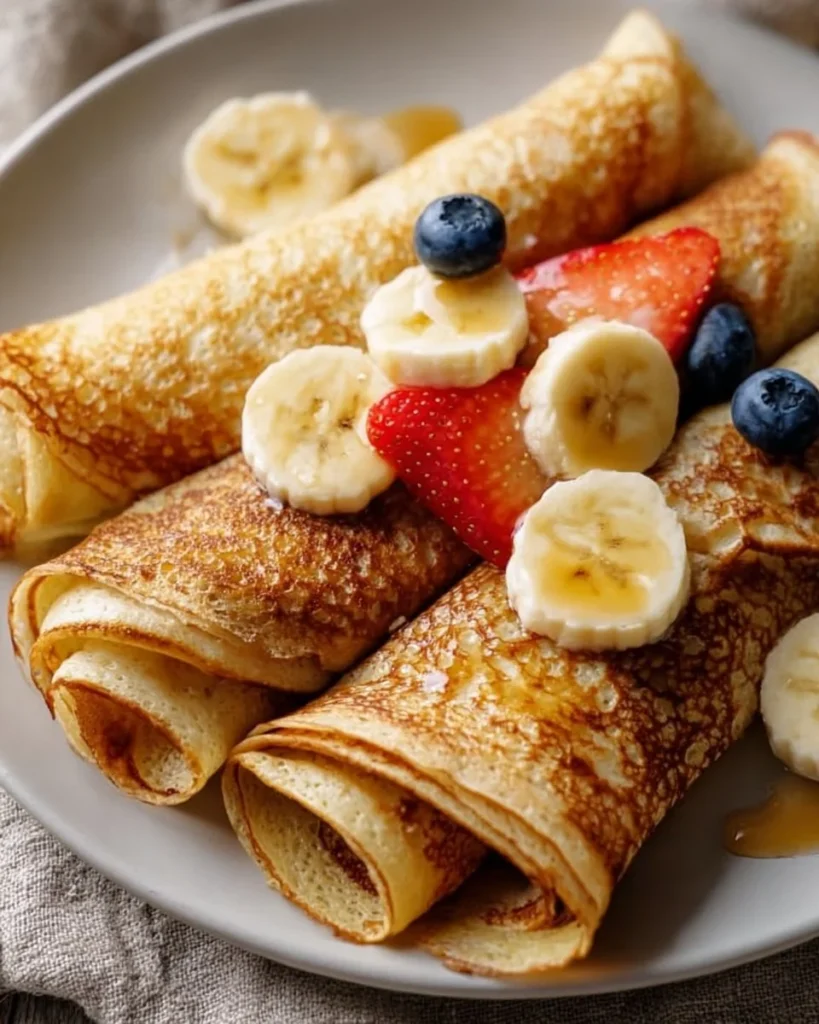 High protein oatmeal crepes served with fresh fruit and syrup.