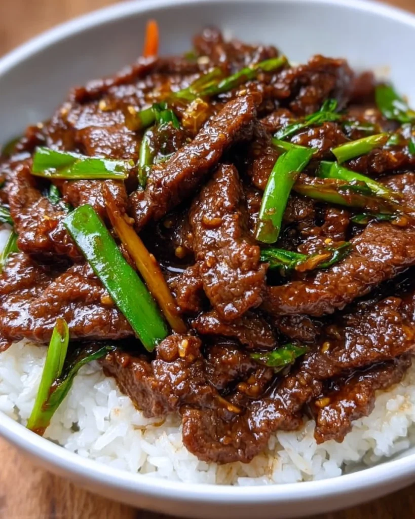 Plate of Mongolian Beef with rice and vegetables, showcasing a delicious stir-fry.