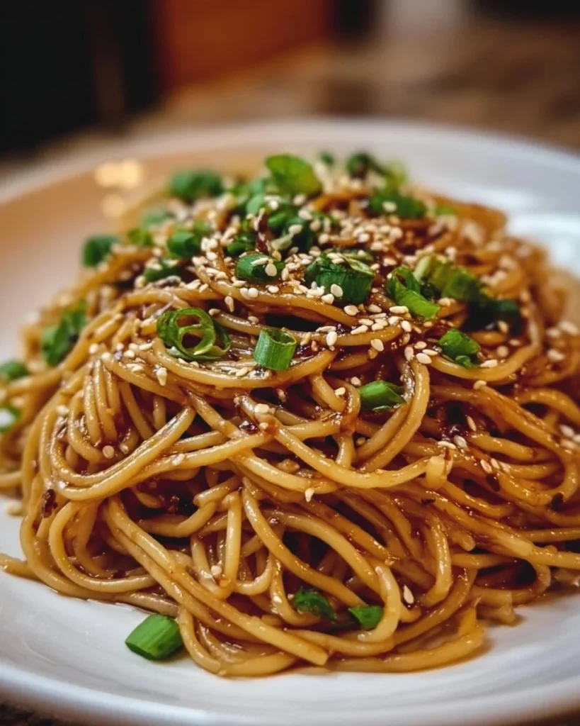 Delicious Garlic Sesame Noodles garnished with sesame seeds and green onions