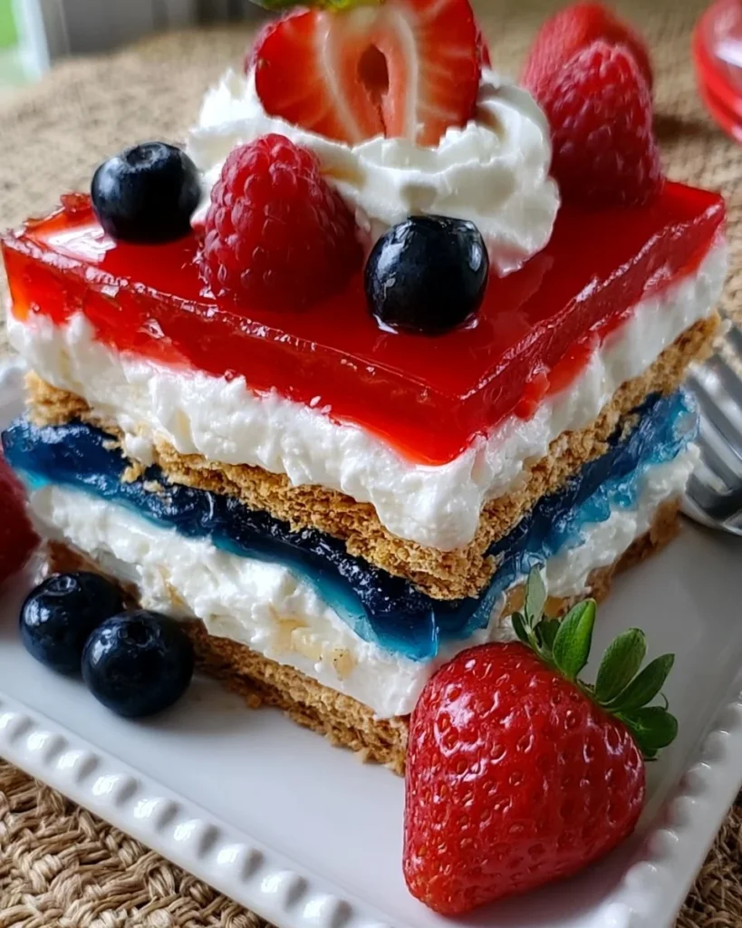 Patriotic dessert lasagna with red, white, and blue layers of cream and fruit